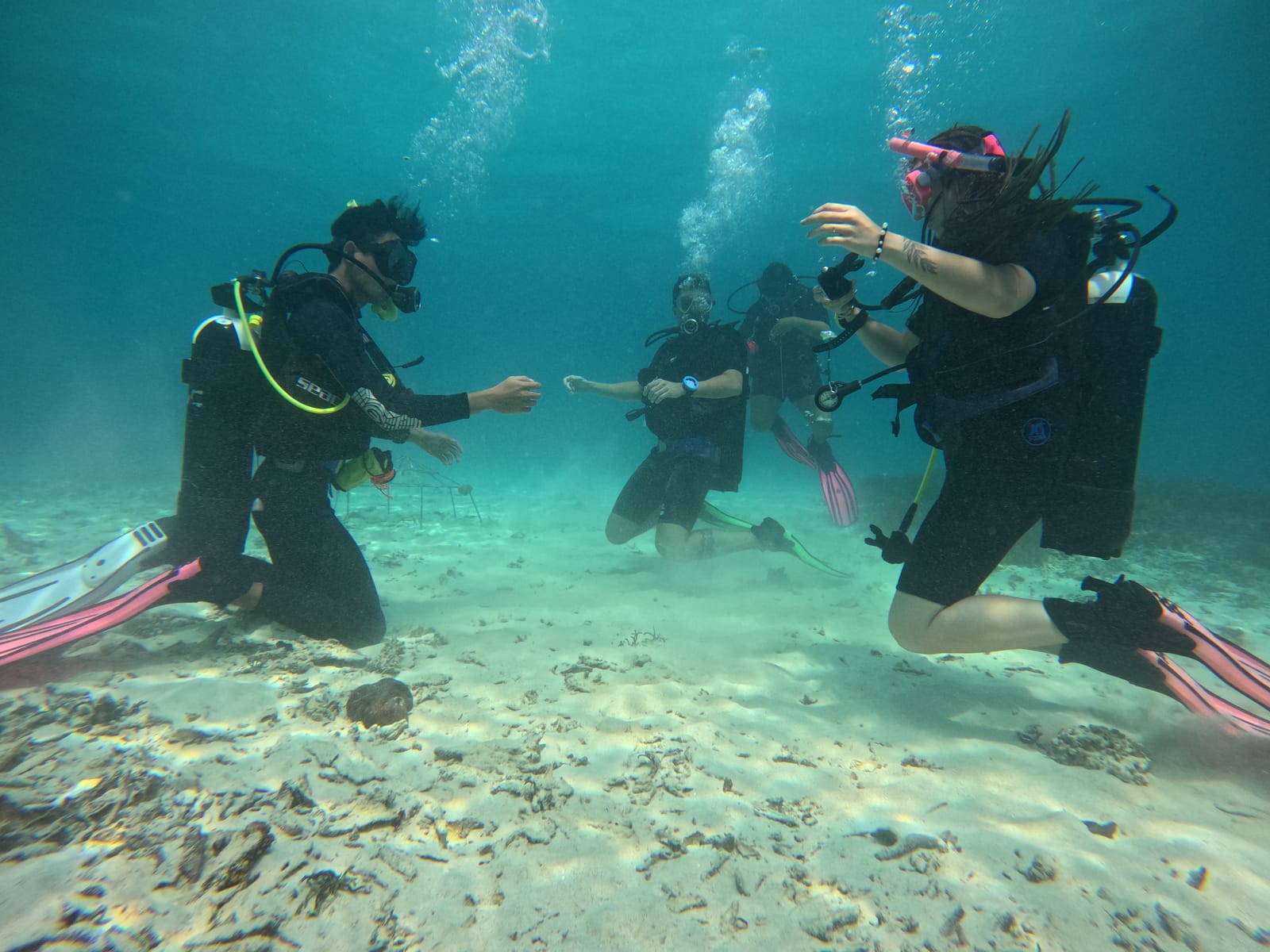 Open Water students practising skills with their instructor on the sandy sea floor off Gili Trawangan